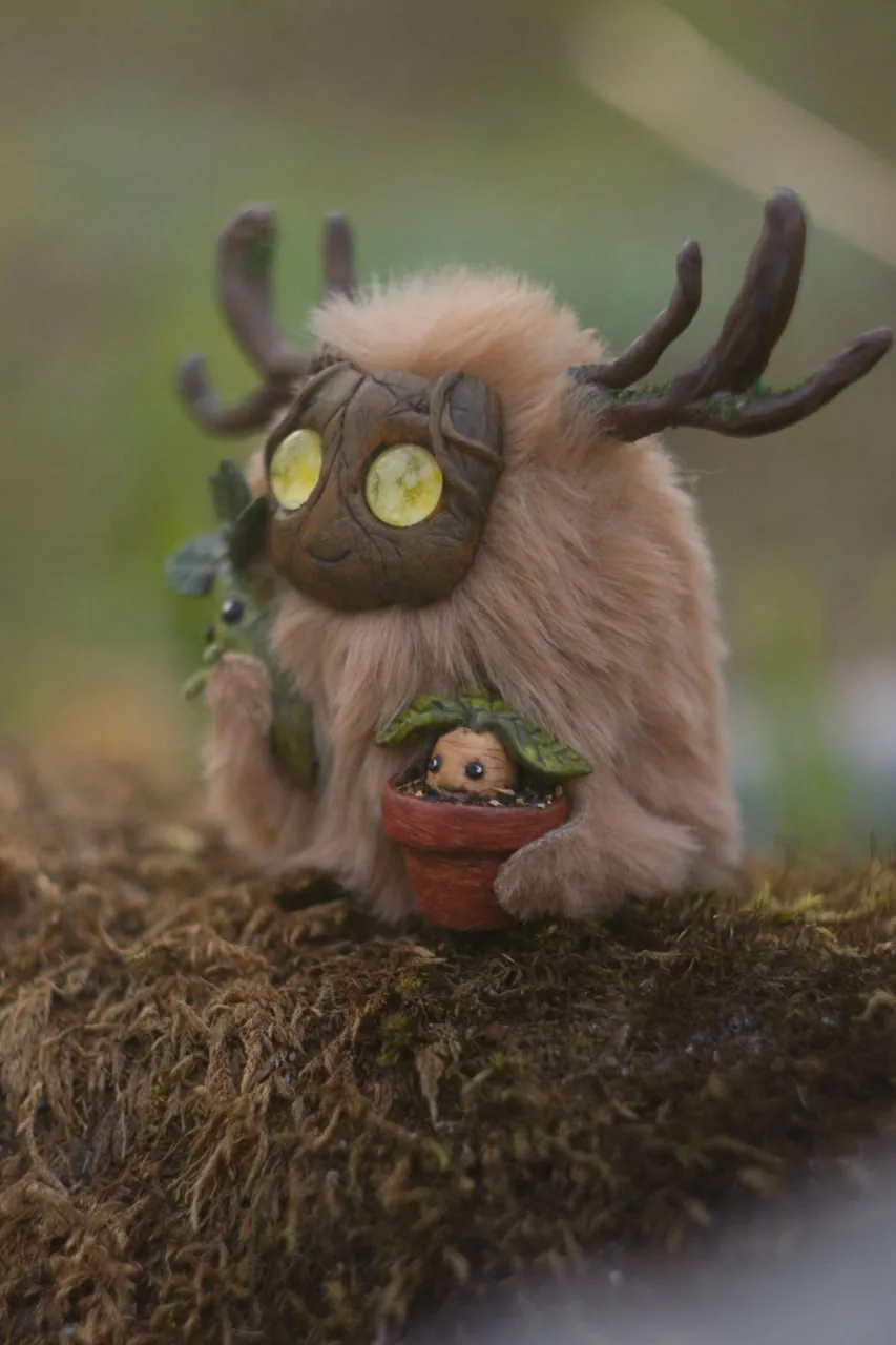 Botanist's Apprentice fluffy — sitting with Mandrake pot in a mossy garden