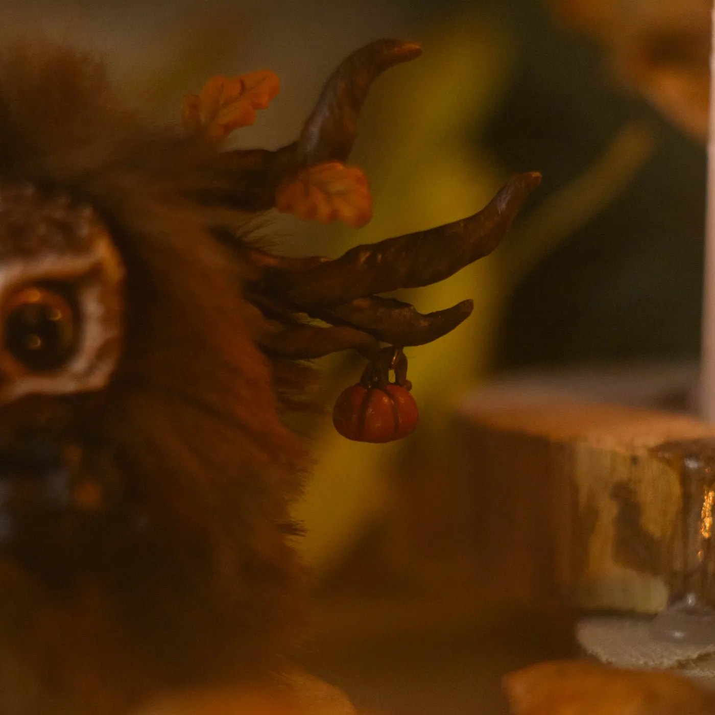 Dear Friend fluffy — close-up of antlers with autumn leaves and hanging pumpkin charm