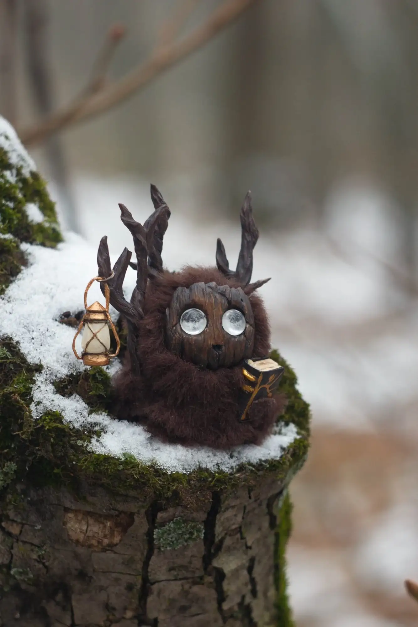 Storyteller fluffy — held in hand showing size, dark brown wool and antlers