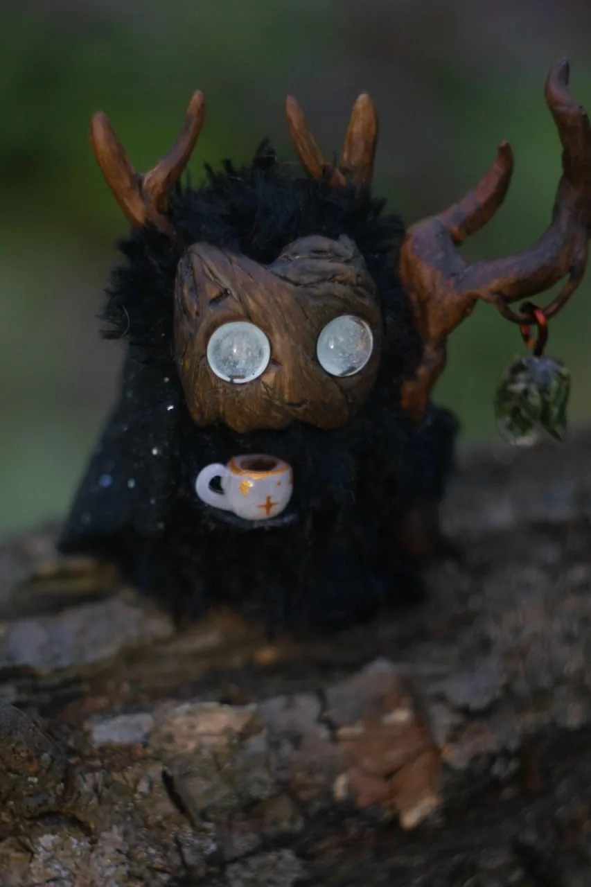 Evening Gazer fluffy — holding a small teacup, cosy spring evening in the garden