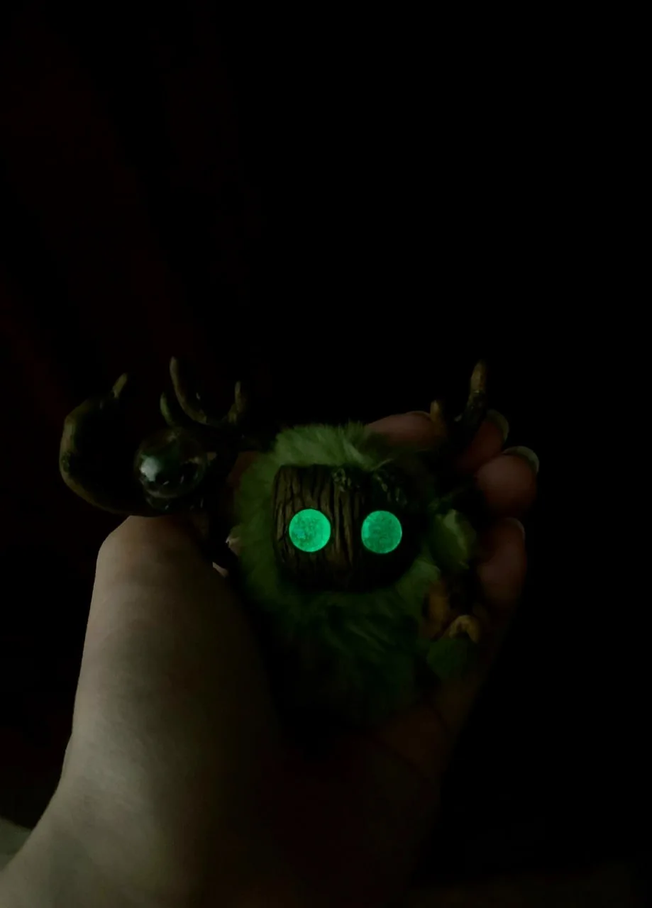 Greenhouse Keeper fluffy — vivid green eyes glowing in darkness