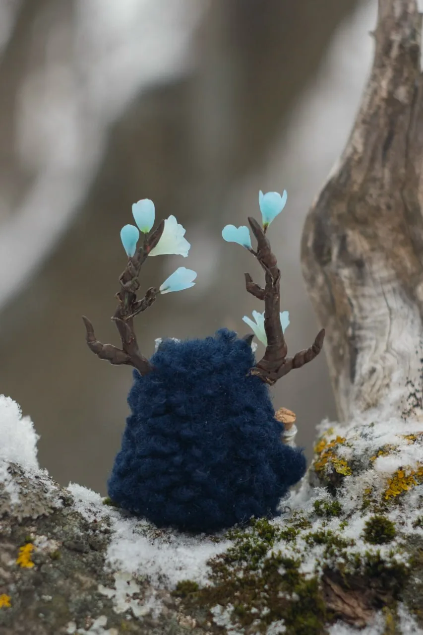 Iceblossom fluffy — back view showing dark navy curly wool and branching antlers with ice blooms