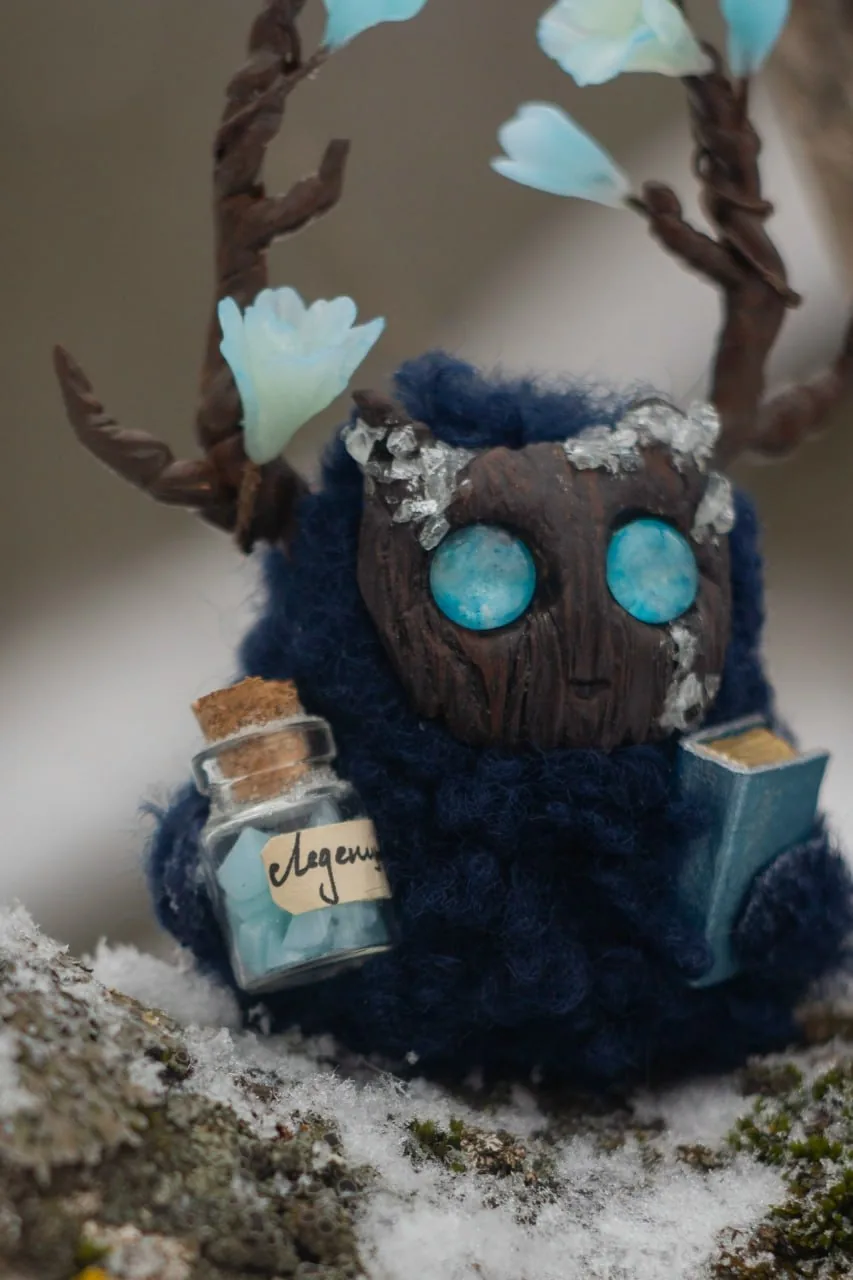Iceblossom fluffy — close-up of carved wooden face with ice crystal crown and mint candy bottle