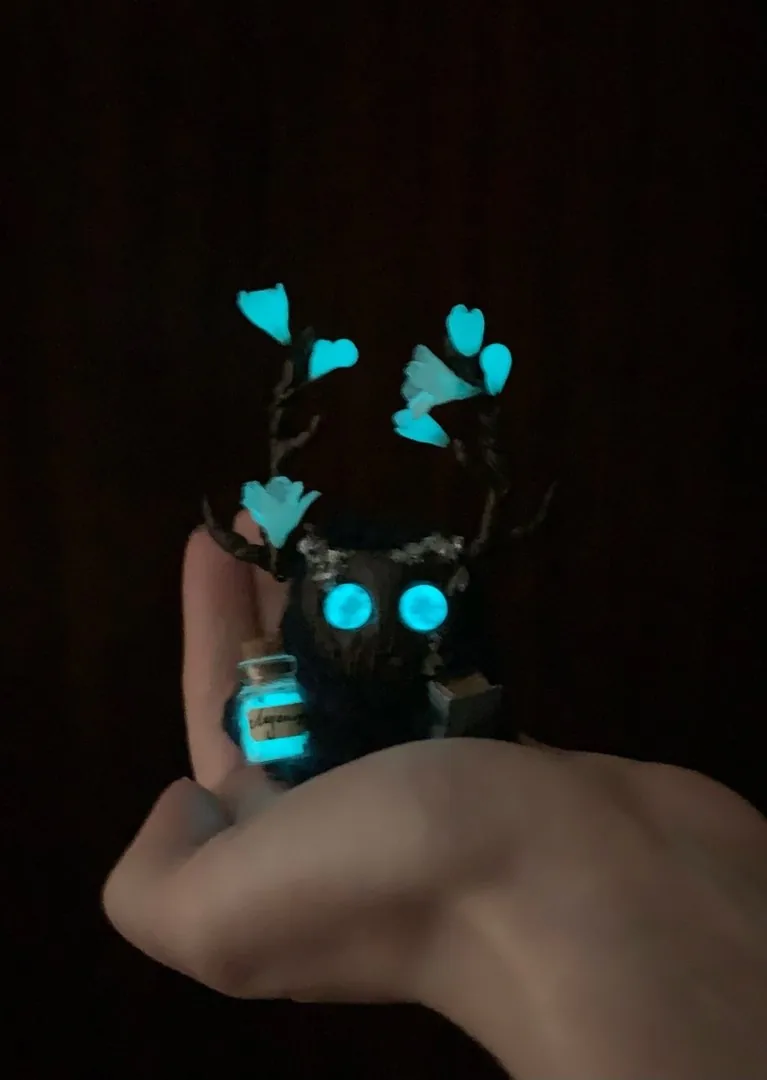 Iceblossom fluffy — turquoise eyes, ice flowers and bottle all glowing blue in complete darkness