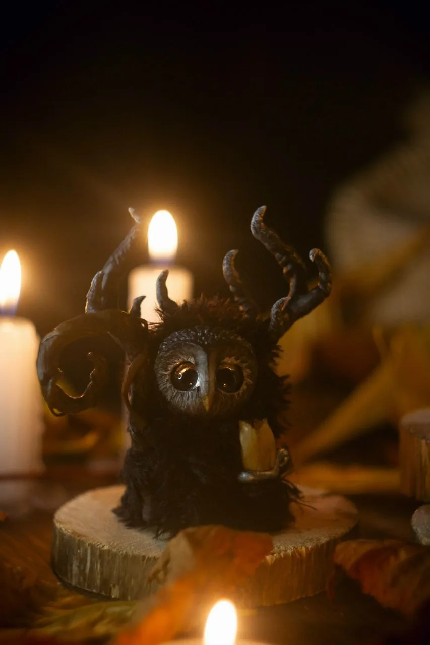 Night Wanderer — handmade black wool Fluffy owl-creature with dark branching antlers and glowing eyes, by candlelight | Gnomenlands