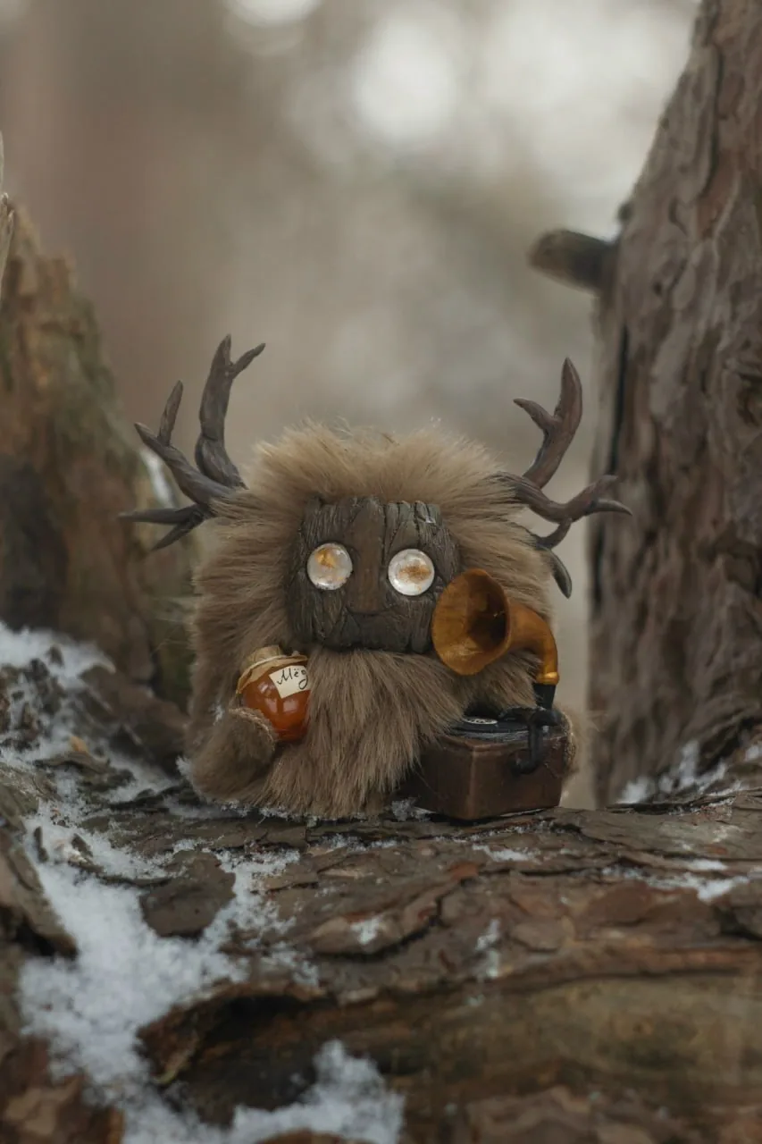 Nostalgia — handmade brown wool Fluffy creature with antlers, holding a honey jar next to a miniature gramophone on a snowy log | Gnomenlands