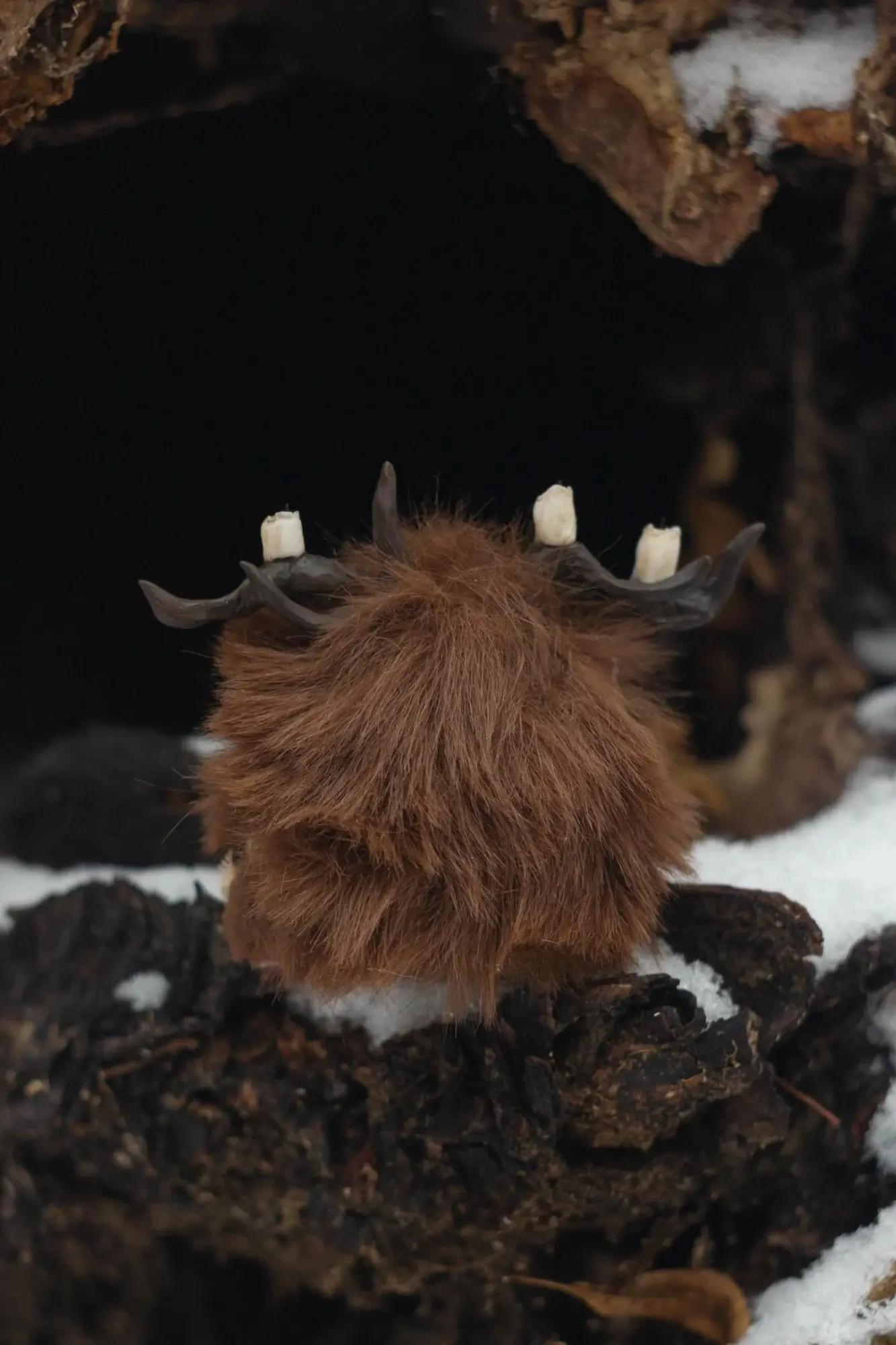 Page Rustle fluffy — back view showing dark brown wool texture and small horns