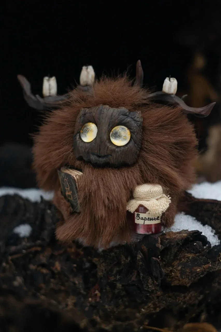 Page Rustle — handmade dark-brown wool Fluffy creature with golden glowing eyes, holding a tiny jam jar and book | Gnomenlands