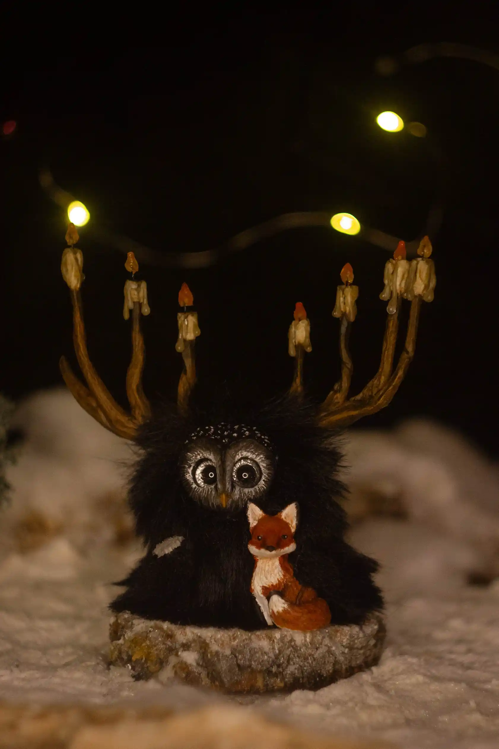 The Glow -- handmade dark Fluffy with branching candle-antlers holding a small red fox kit, snowy woodland scene | Gnomenlands, Winter Glow collection