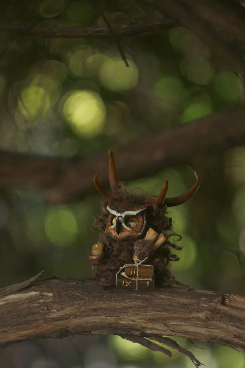 Wise Owl fluffy — close-up portrait with glowing eyes and antler branches