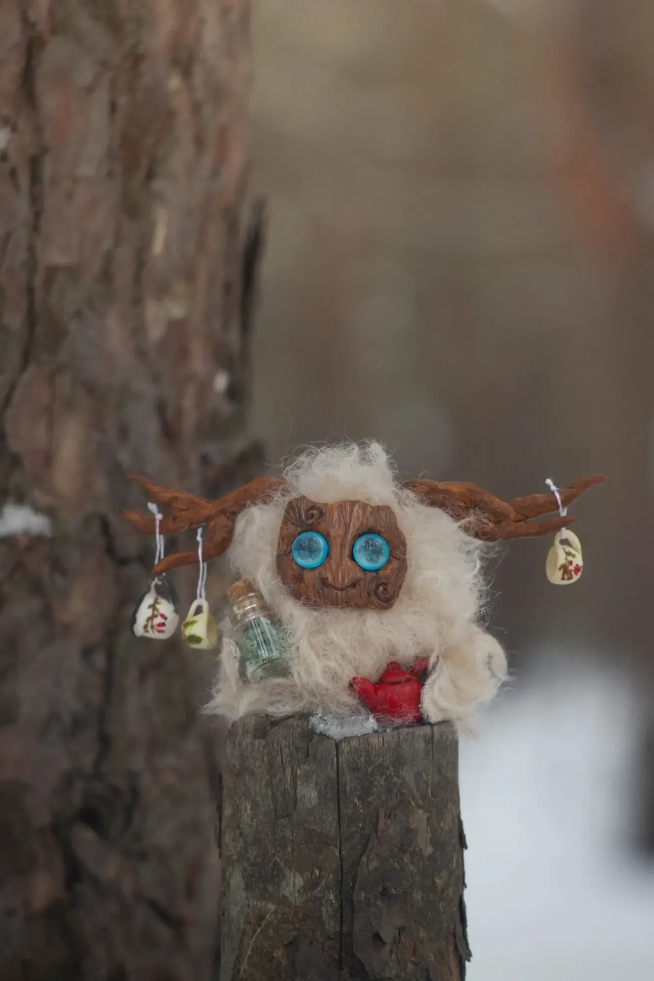 Yeti fluffy — front view on a stump by a tree, white wool, blue eyes, antlers with teacups and potion bottle