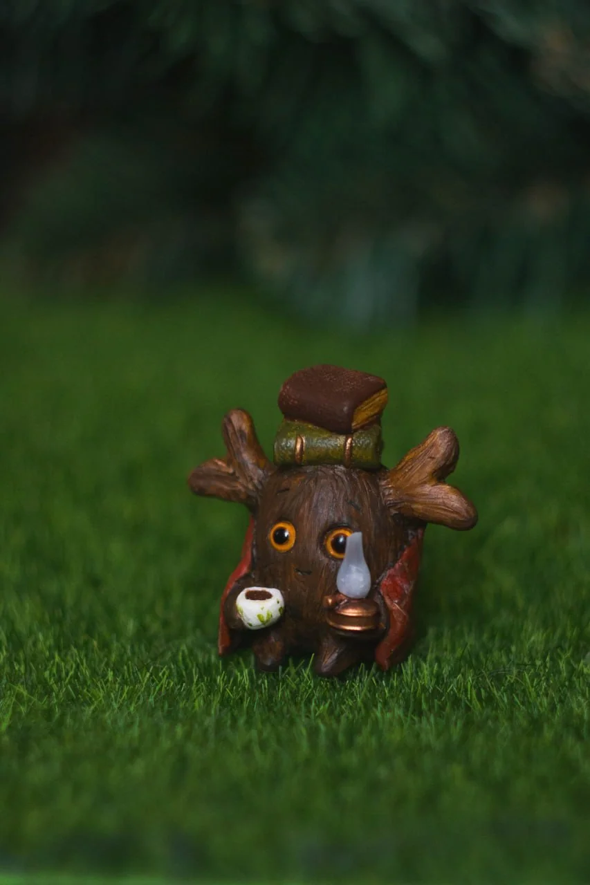 Forest Sprite Bookworm — closeup of amber eyes, kerosene lamp and cocoa mug detail