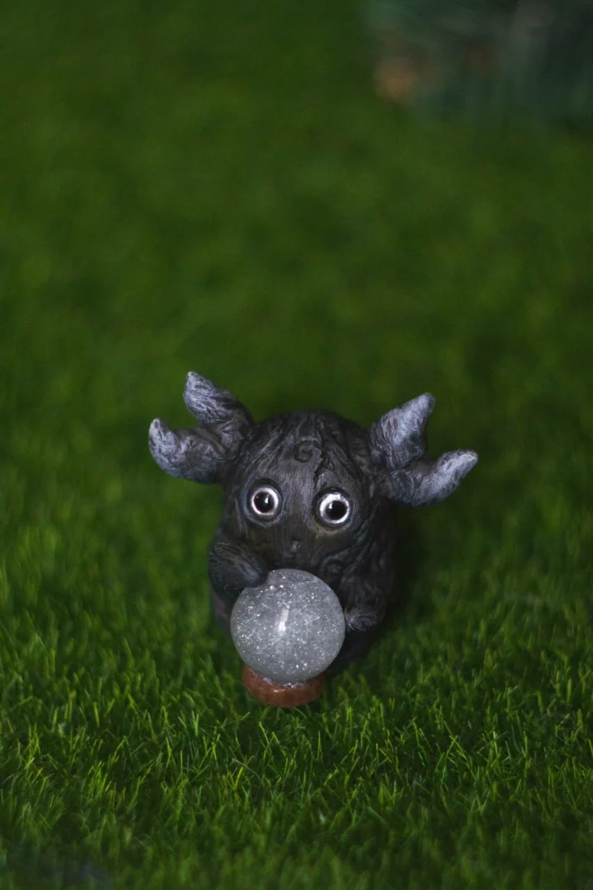 Forest Sprite Oracle — back view, dark textured body and antler-like horns