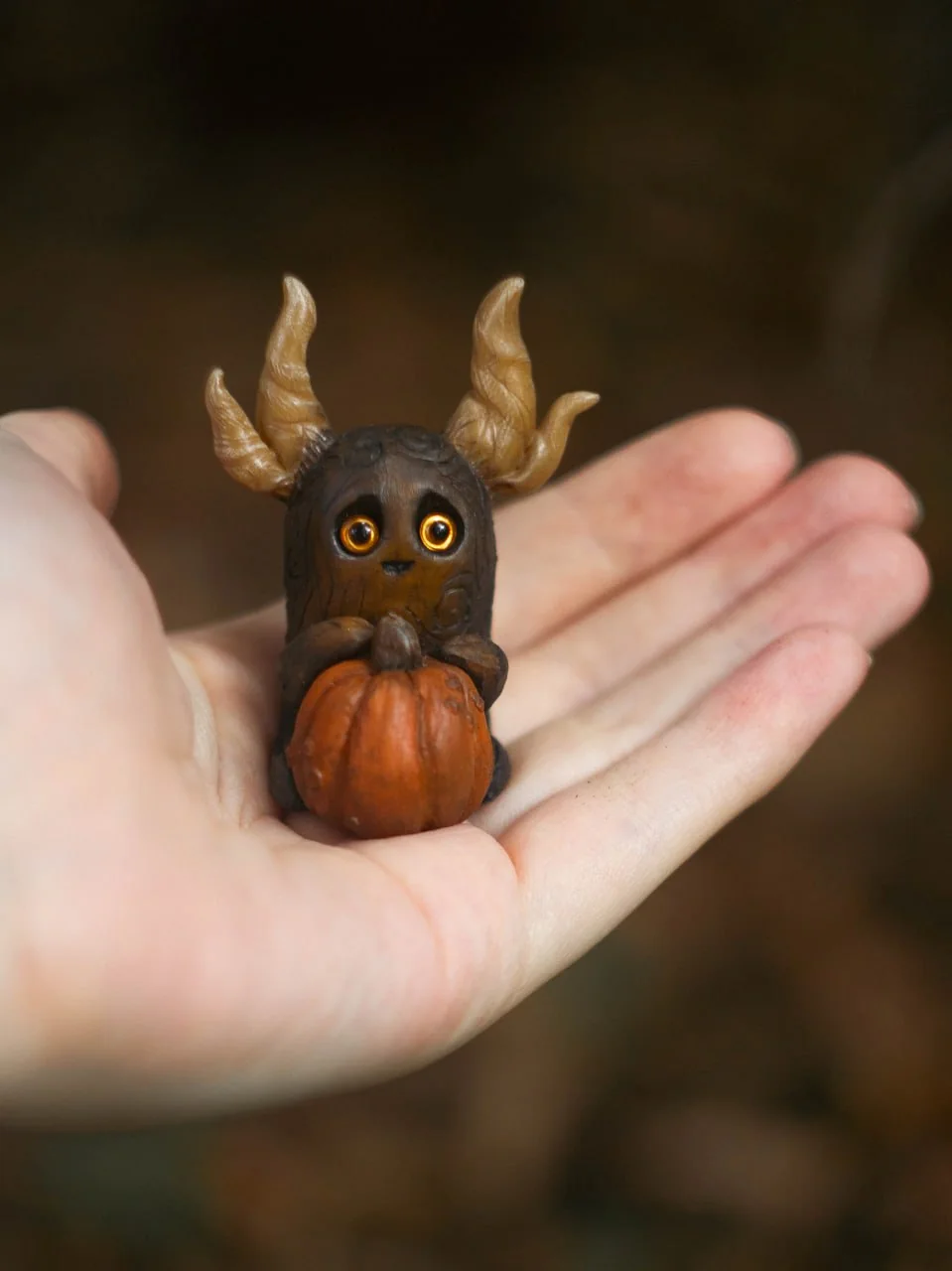 Forest Sprite Pumpkin Keeper held in palm — size comparison showing ~6 cm height