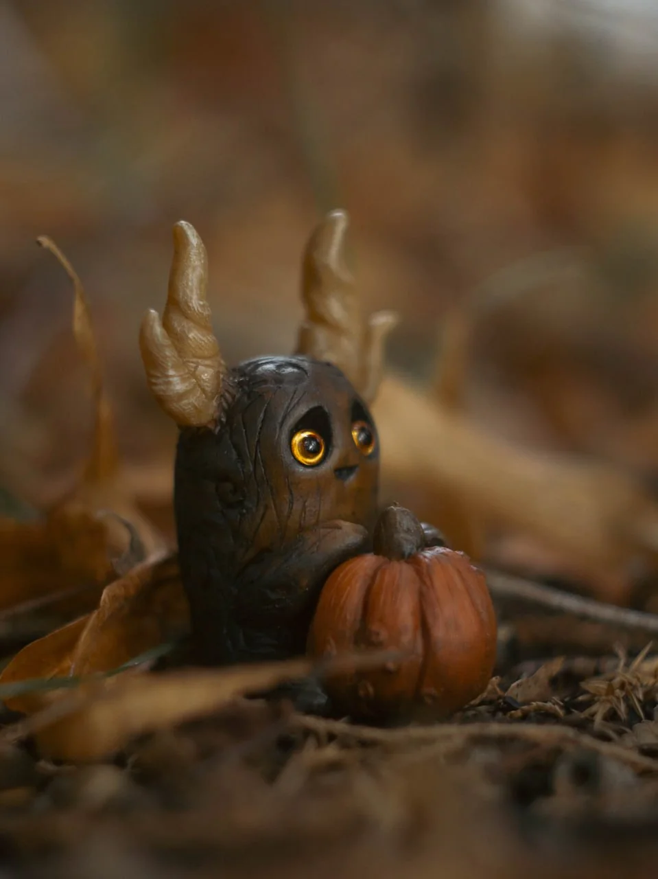 Forest Sprite Pumpkin Keeper — with orange pumpkin among fallen autumn leaves