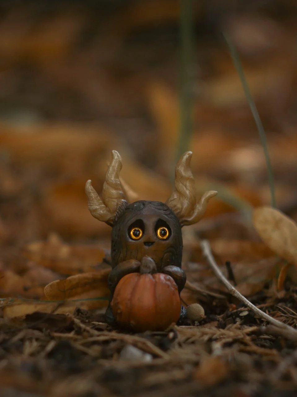 Forest Sprite Pumpkin Keeper — front view on autumn forest floor covered in leaves