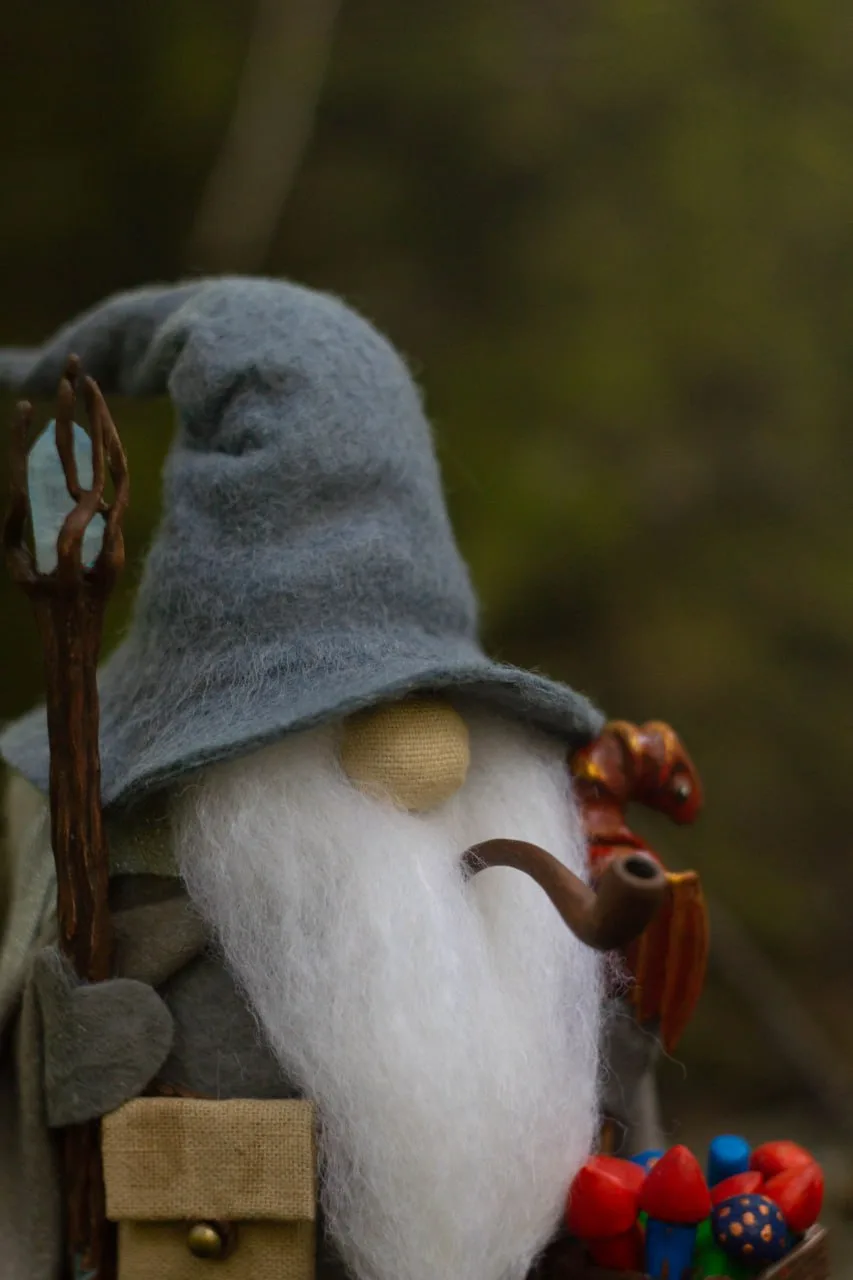 Scandinavian gnome in grey hat with smoking pipe — closeup