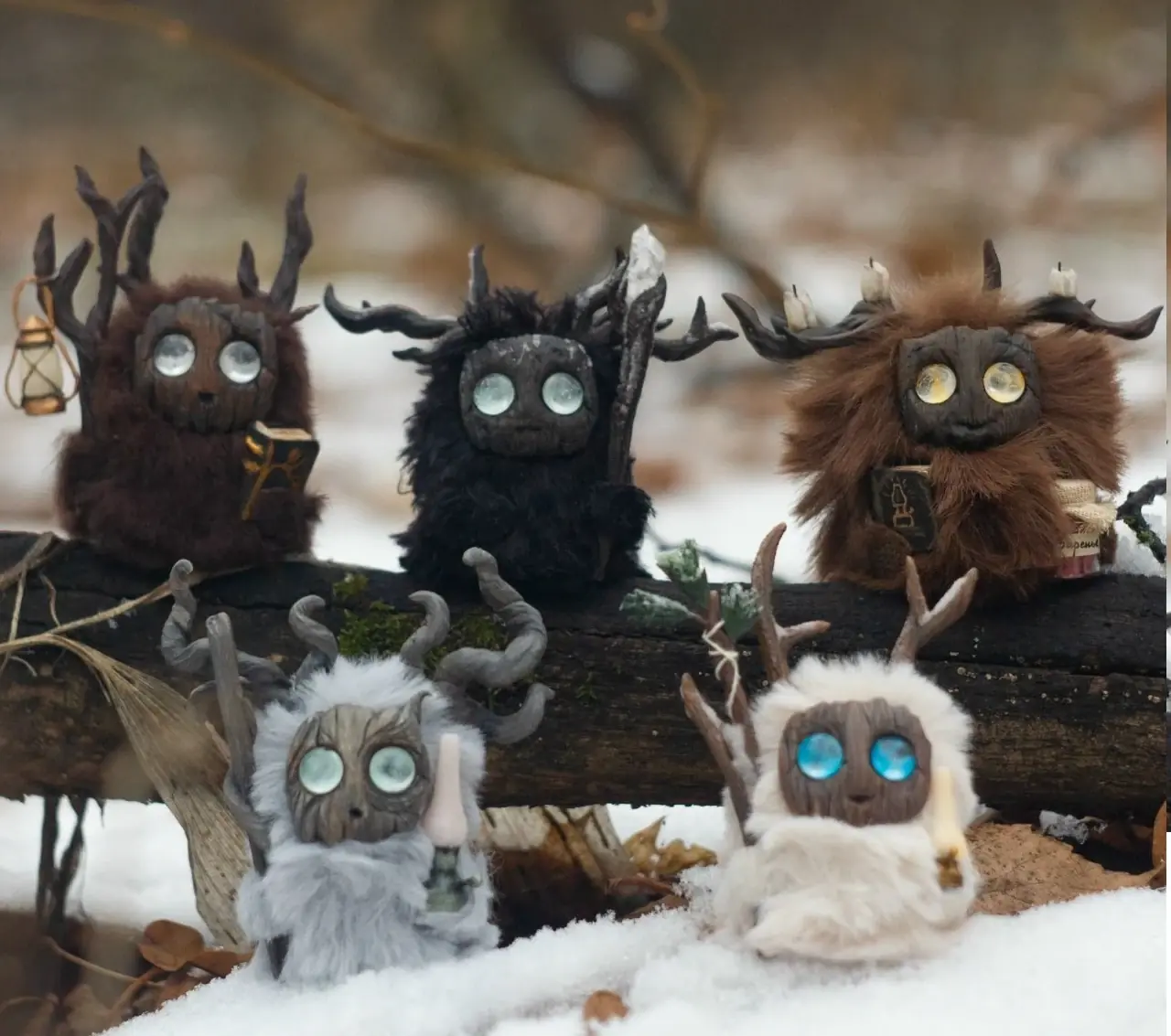 Five handmade Fluffy forest creatures sitting on a snow-covered log in winter woodland — Gnomenlands collectibles
