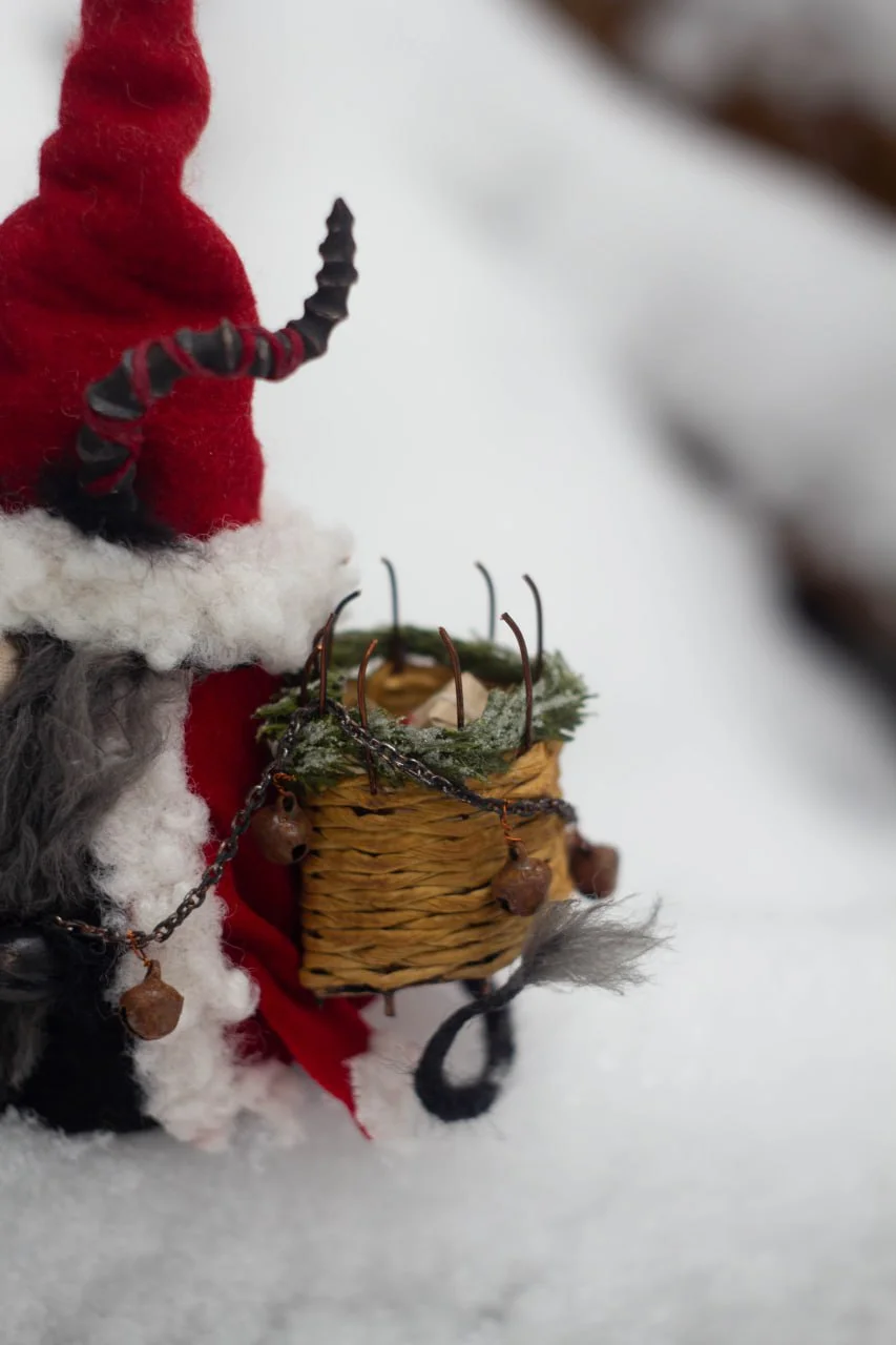 Interior Gnome Krampus with wicker basket and pine branch — closeup