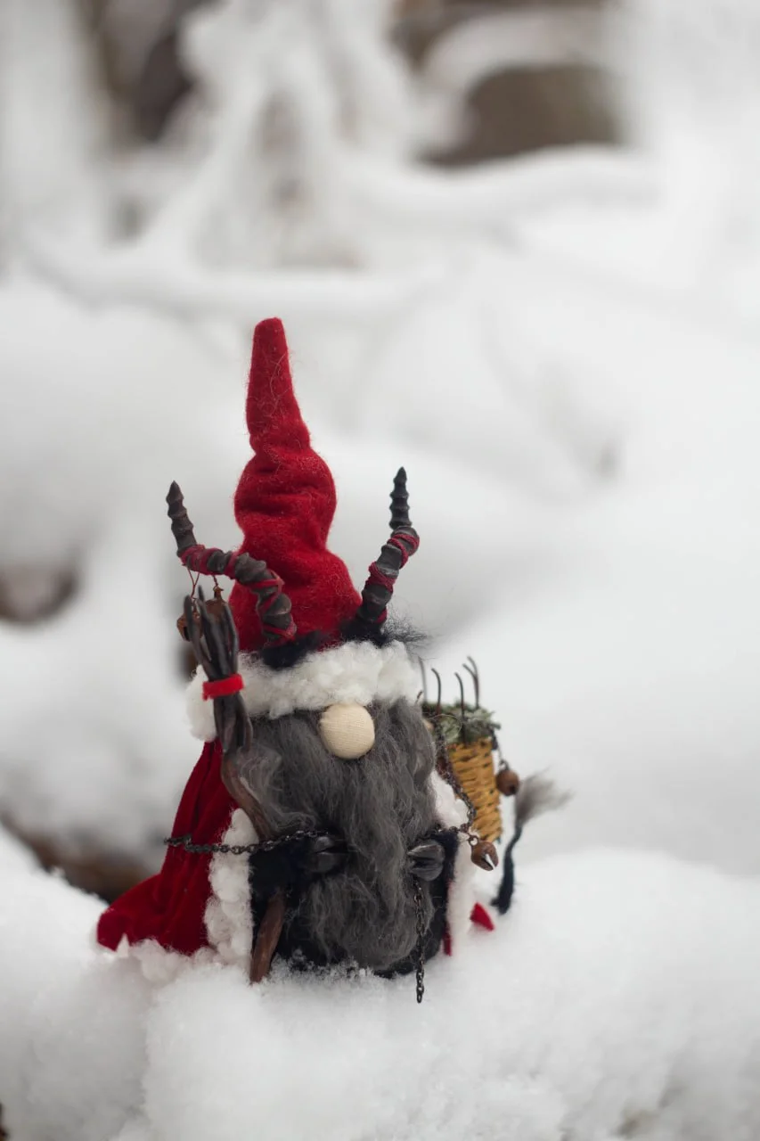 Traditional folklore Gnome Krampus — side view on snowy rocks