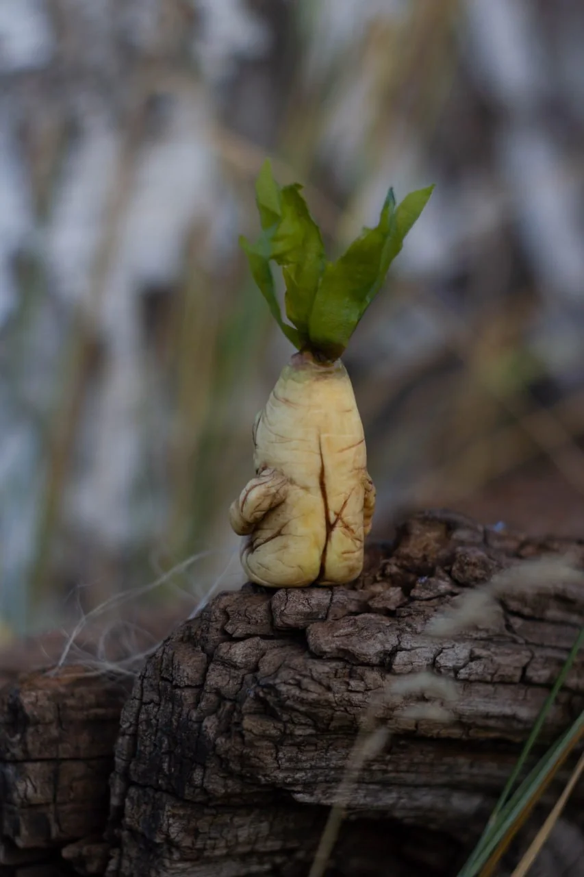 Handmade classic mandrake figurine back view — sculpted root body and green leaf crown