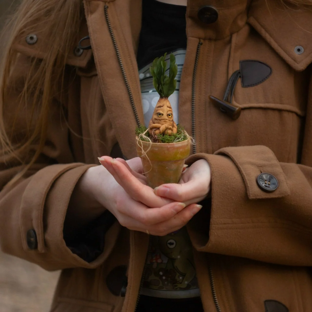 Small mandrake in pot held gently in cupped hands — handmade polymer clay collectible
