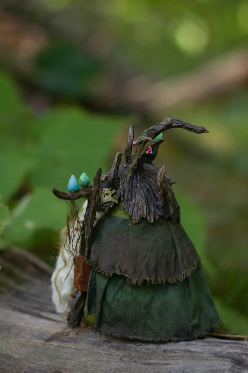 Swamp gnome with green cloak, glowing wisps and magic staff