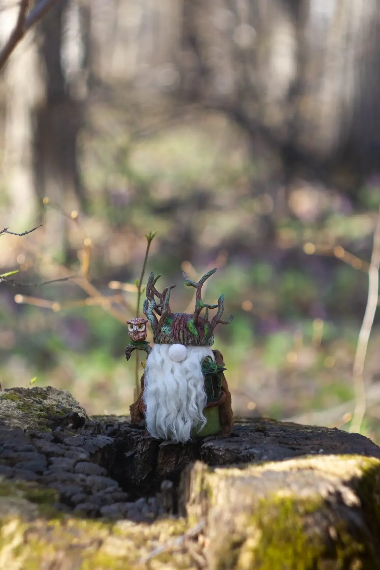 Gnome Night Warden figure — on a stump in spring forest with wildflowers