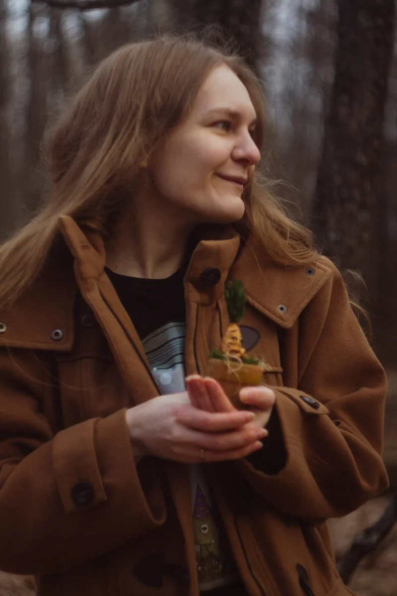 Olesya — author and creator of Gnomenlands workshop, holding a handmade gnome in the forest