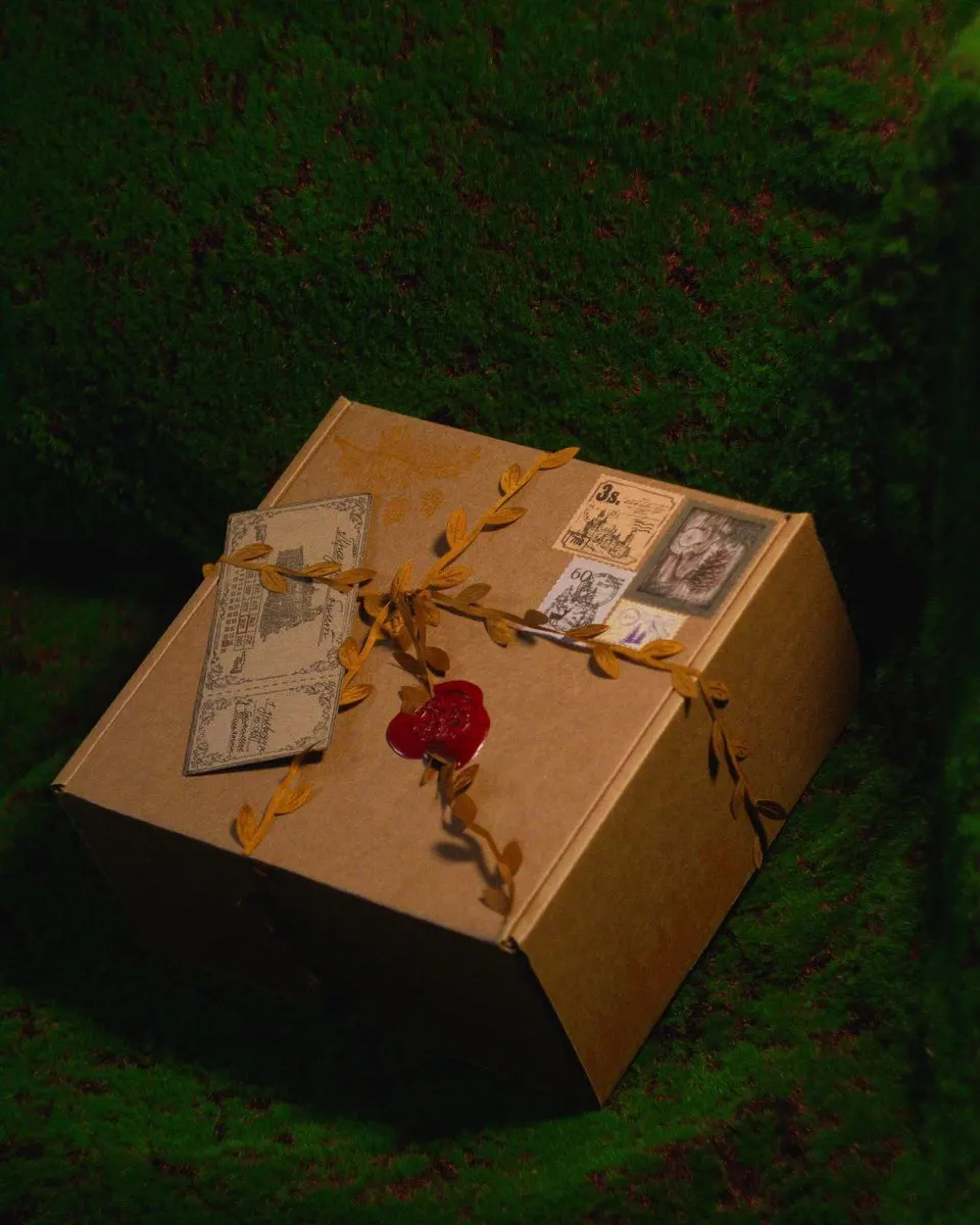 Gnomenlands packaging box — kraft box with golden autumn leaf garland, vintage stamps and red wax seal