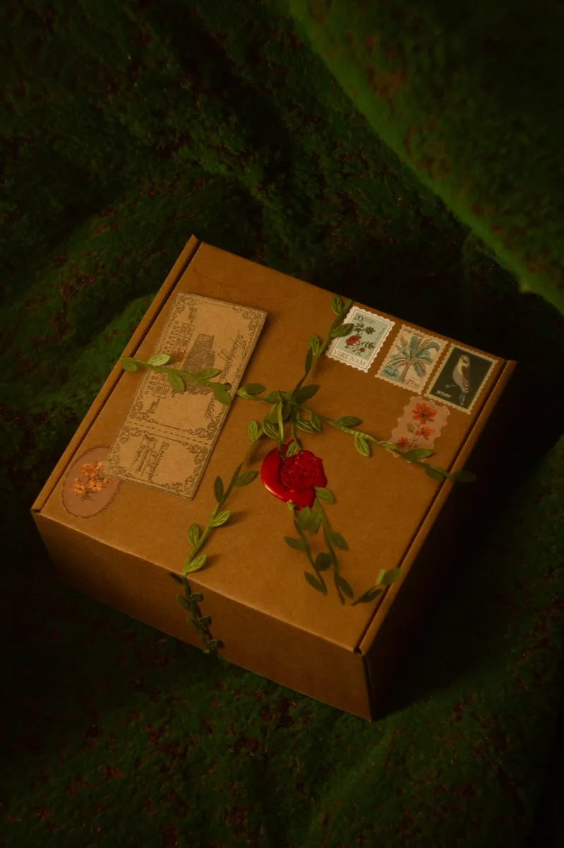 Gnomenlands packaging box — kraft box with green leaf garland, vintage stamps and red wax seal, spring theme