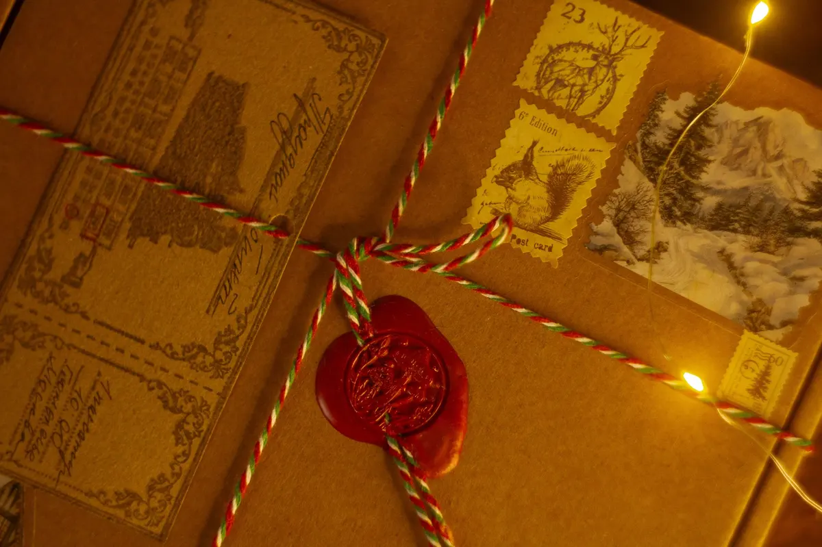 Gnomenlands packaging detail — close-up of red wax seal and forest-themed vintage stamps with twine bow