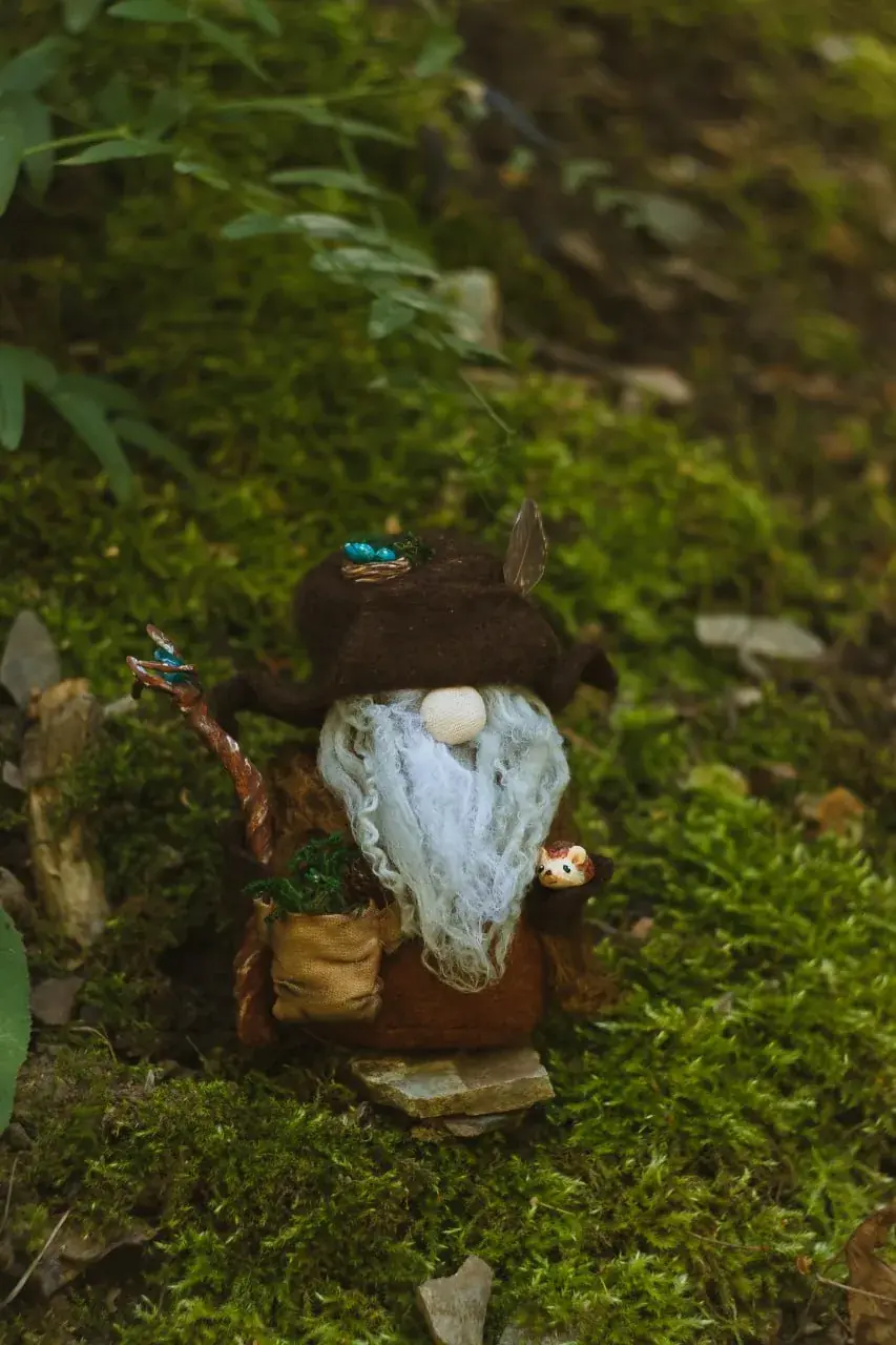 Forest wizard gnome in brown hat with staff and canvas satchel — front view