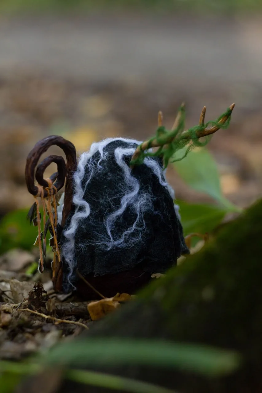 Shaman gnome — side view, staff with shells and antlers among leaves