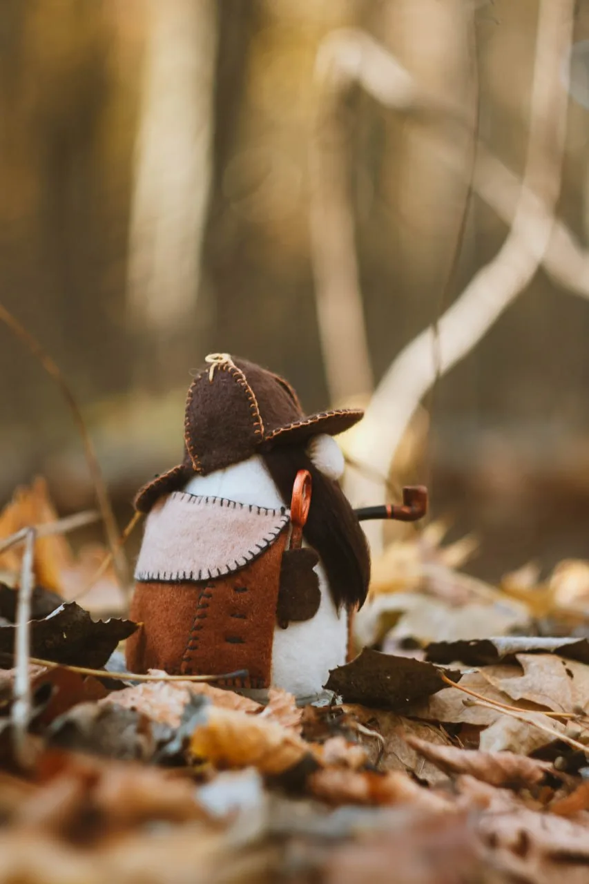 Detective gnome Sherlock Holmes with pipe and magnifier — side view