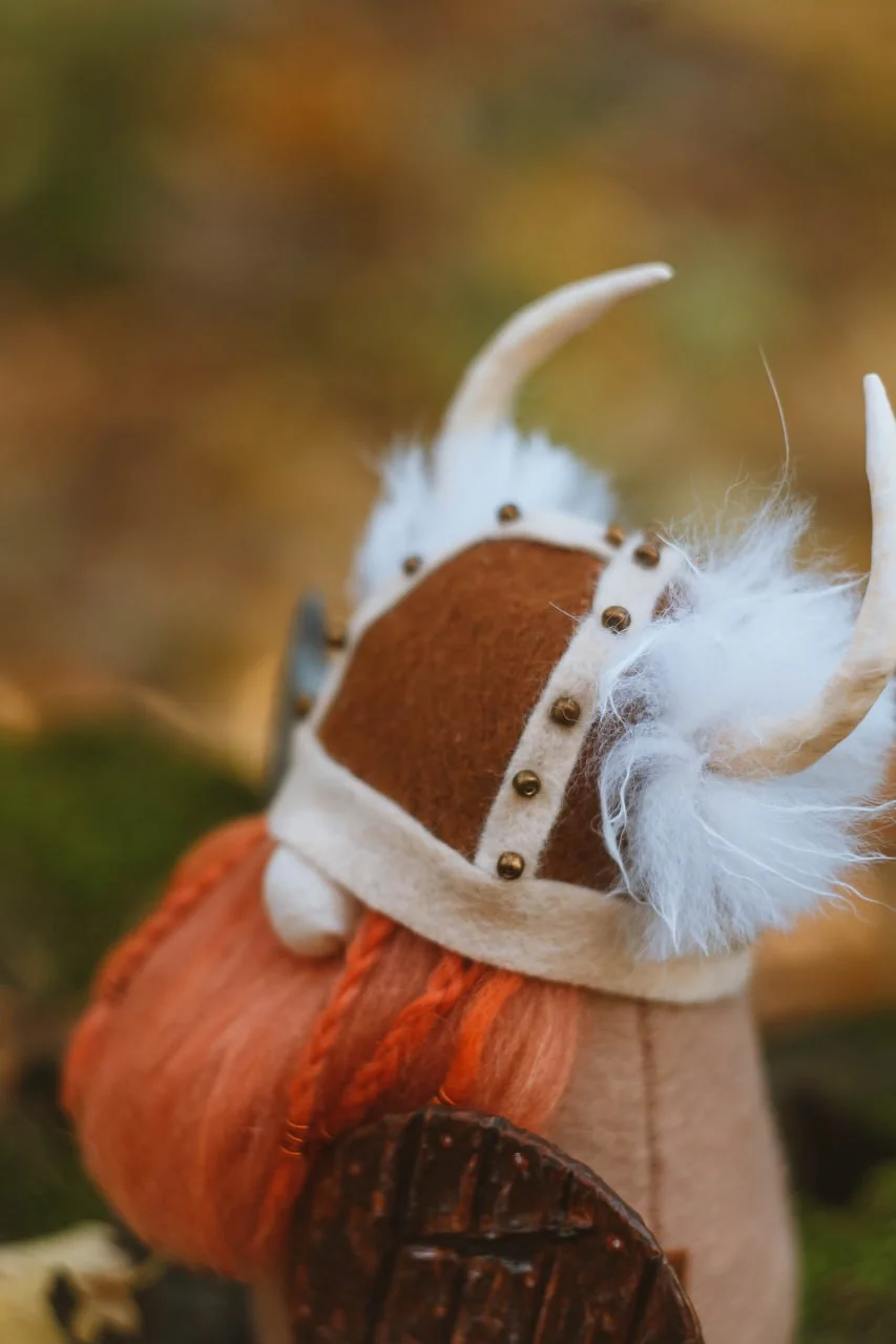Viking gnome's horned helmet with beads and white fur — closeup