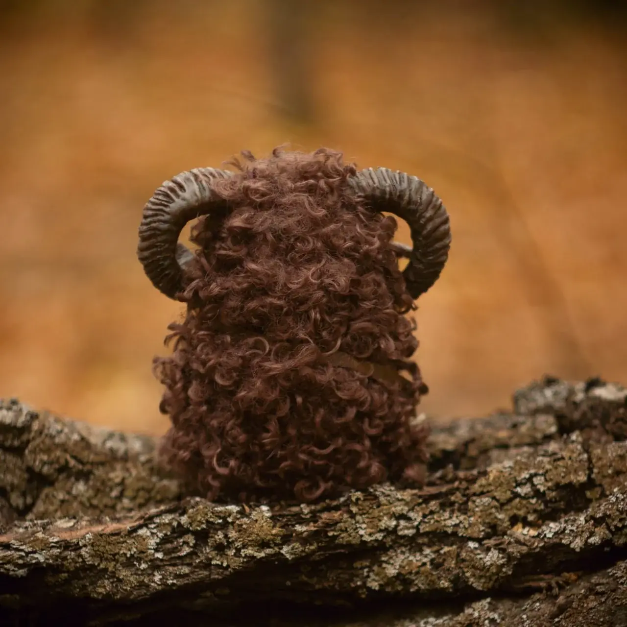 Wood Spirit Faun — rear view, lush curly dark faux fur with coiled ram horns on bark log, handmade artisan collectible fantasy sculpture