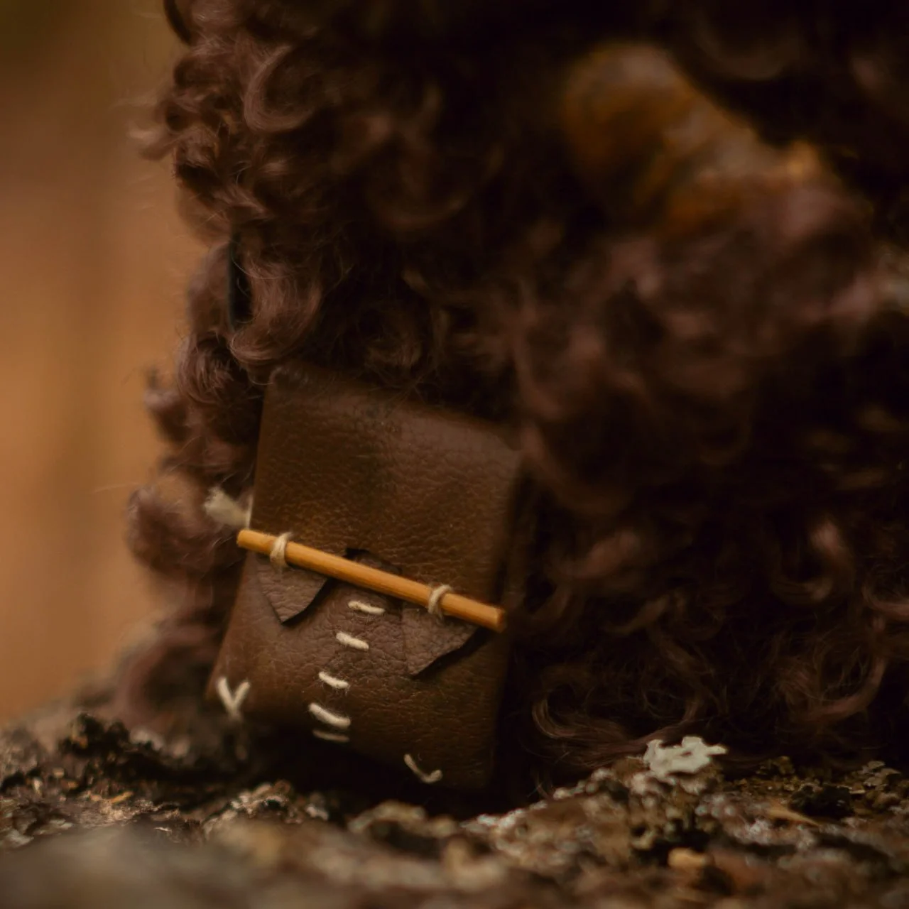 Wood Spirit Faun — side view with mandrake root and fawn, curly dark fur and coiled horns, handmade artisan collectible sculpture inspired by Guillermo del Toro