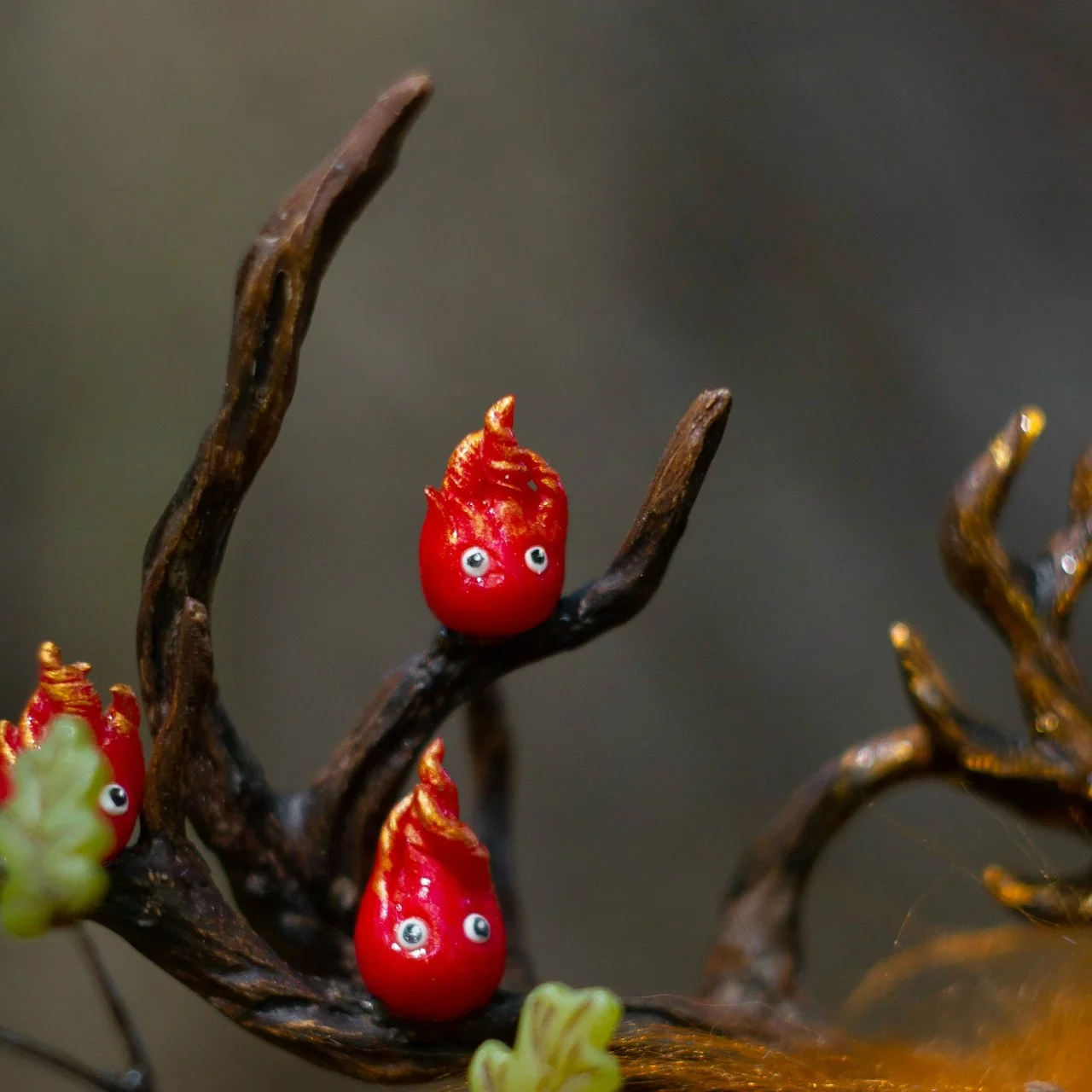Fire spirits on Wood Spirit Litha Flame antlers — handmade polymer clay figurines with glowing eyes and golden flame tips, artisan collectible detail