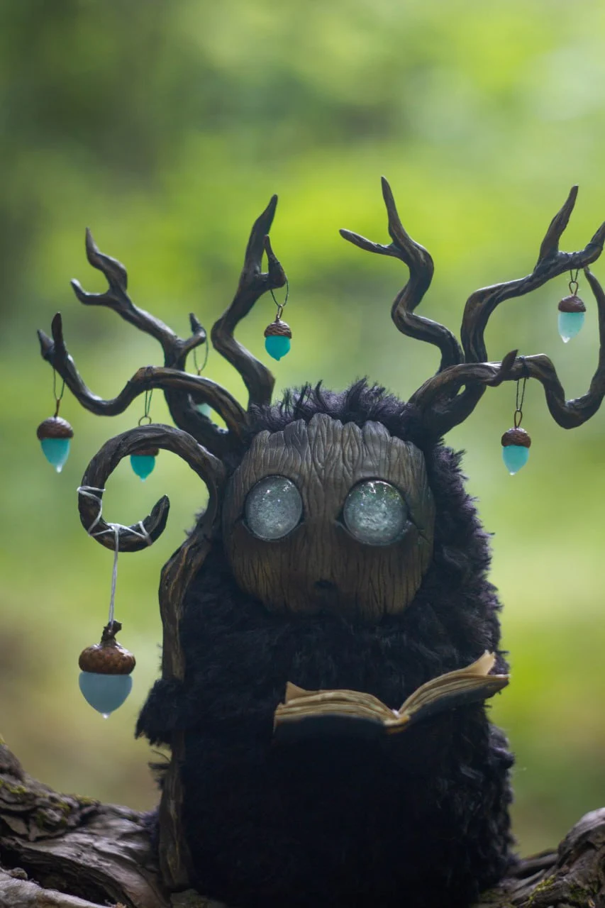 Detailed view of Wood Spirit Midnight Light antlers — handcrafted branches with teal glowing acorn pendants and crescent moon talisman