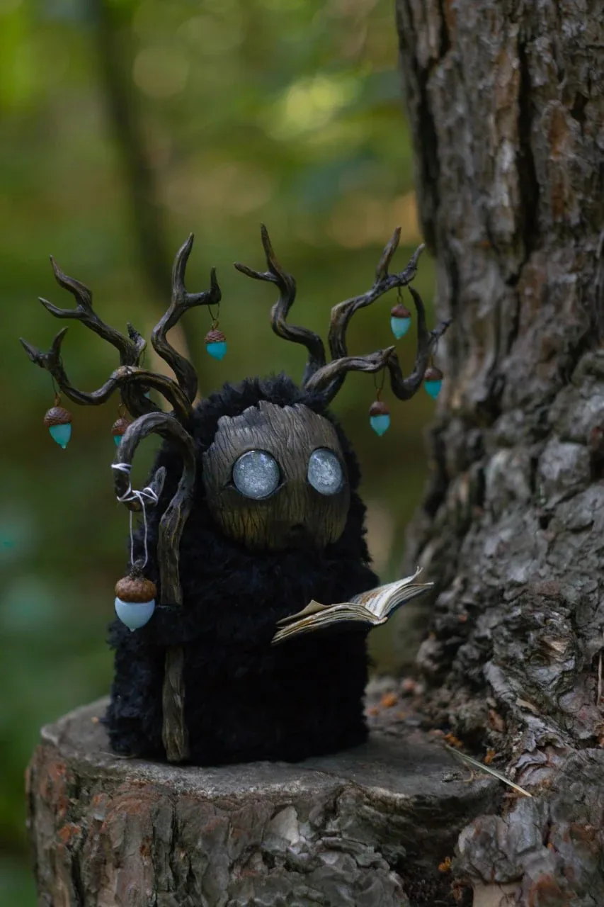 Wood Spirit Midnight Light sitting on a tree stump in the forest — handmade fantasy creature by Gnomenlands