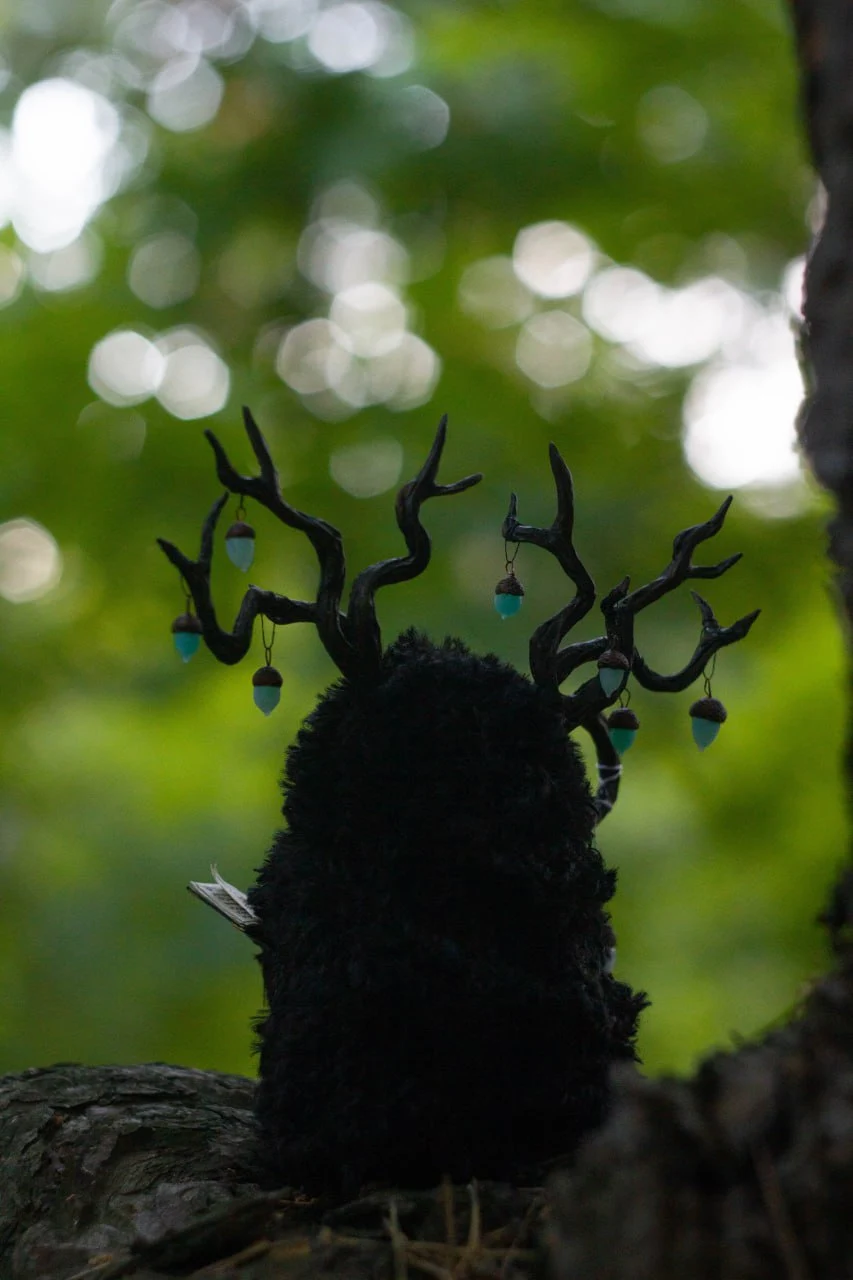 Wood Spirit Midnight Light on mossy forest log — collectible handmade fantasy doll with book and glowing lanterns