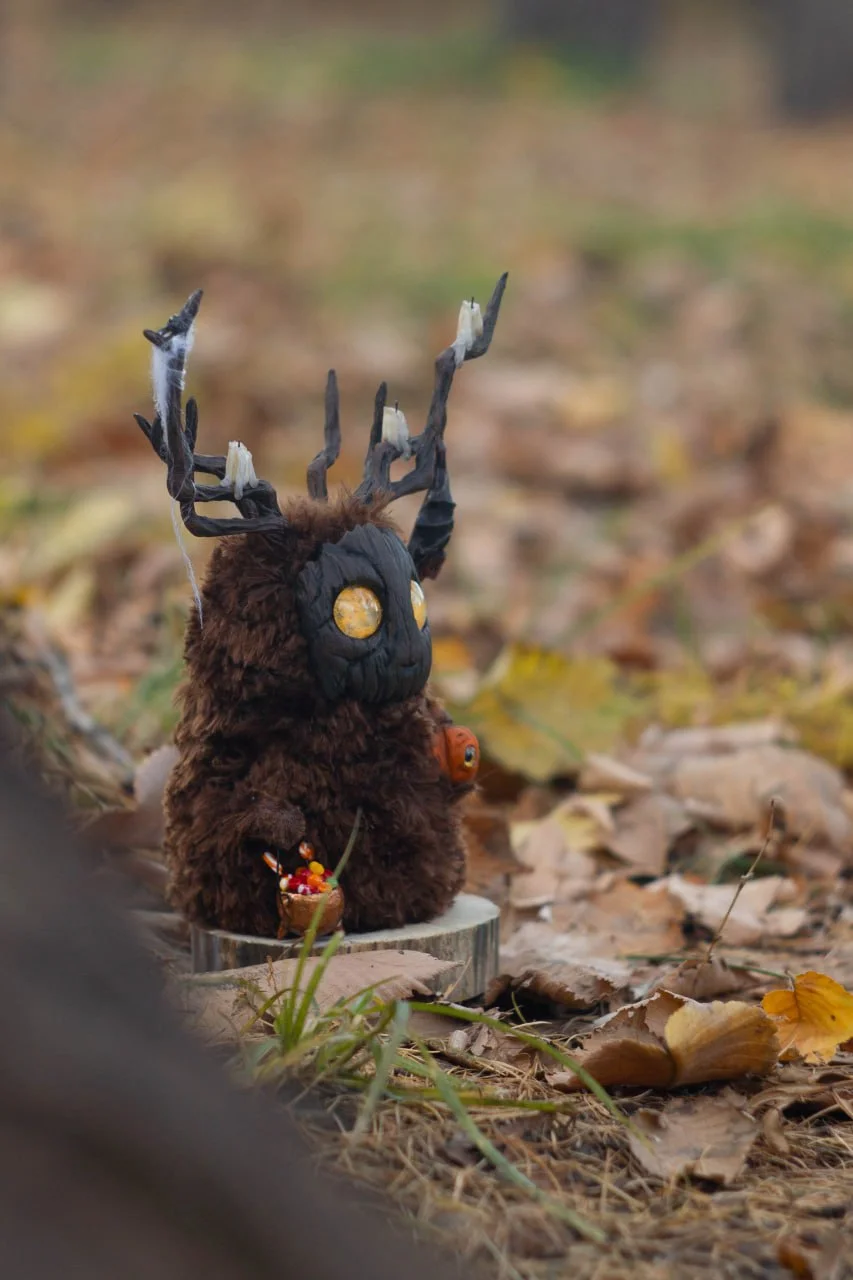 Wood Spirit Samhain Whisper — side view with antlers and autumn forest background, handmade collectible woodland creature sculpture